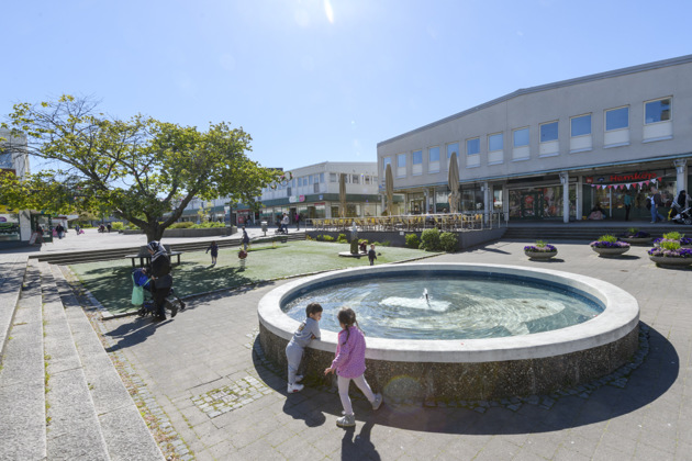 Kortedala Torg på sommaren. Barn som leker vid en fontän.